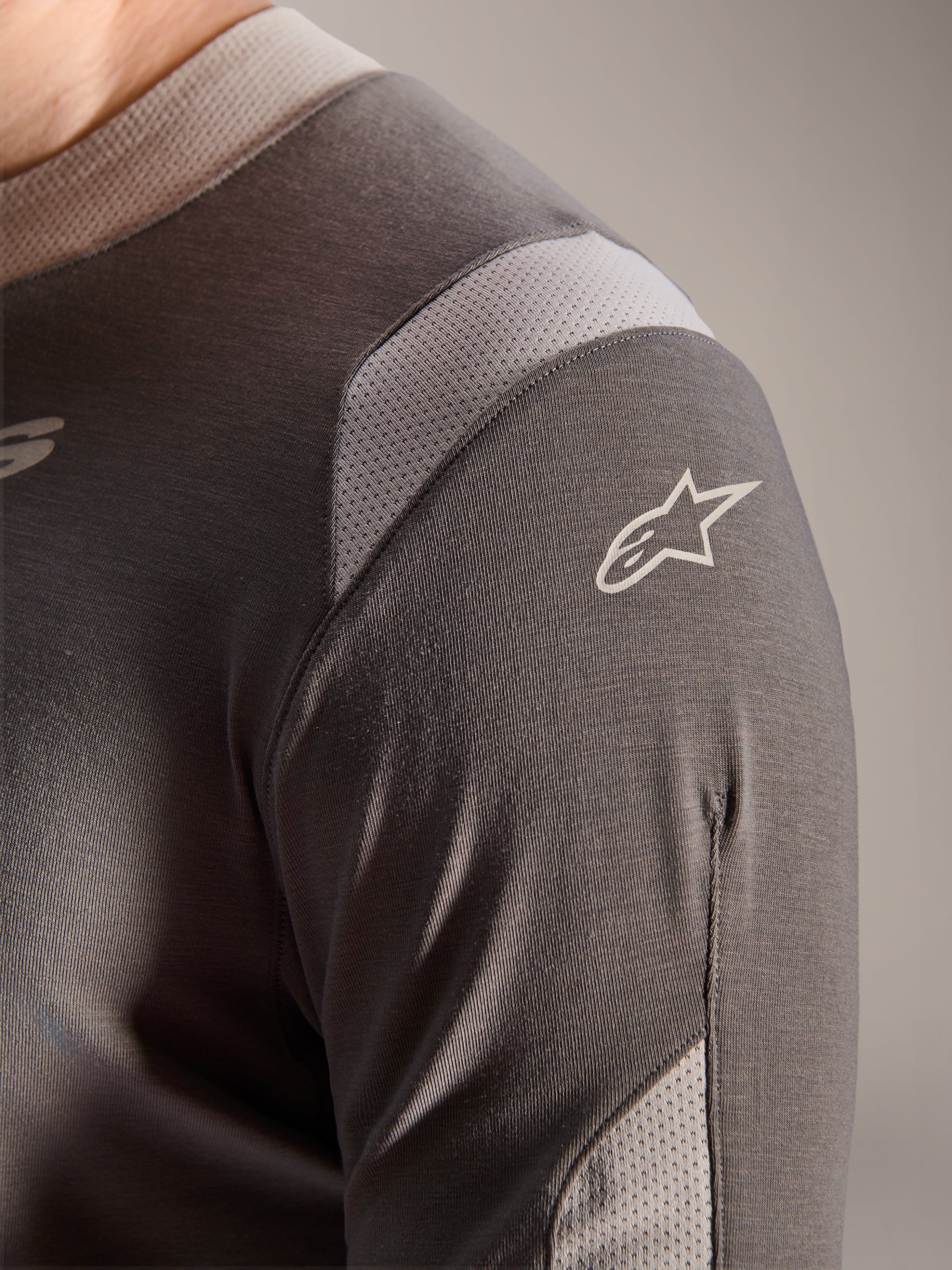 Alpinestars A-Dura Dri Wool Jersey - Long Sleeve, Dark Gray, detailed view of the shoulder and sleeve showing light gray mesh ventilation panels and the white Astars logo on the technical drirelease fabric.