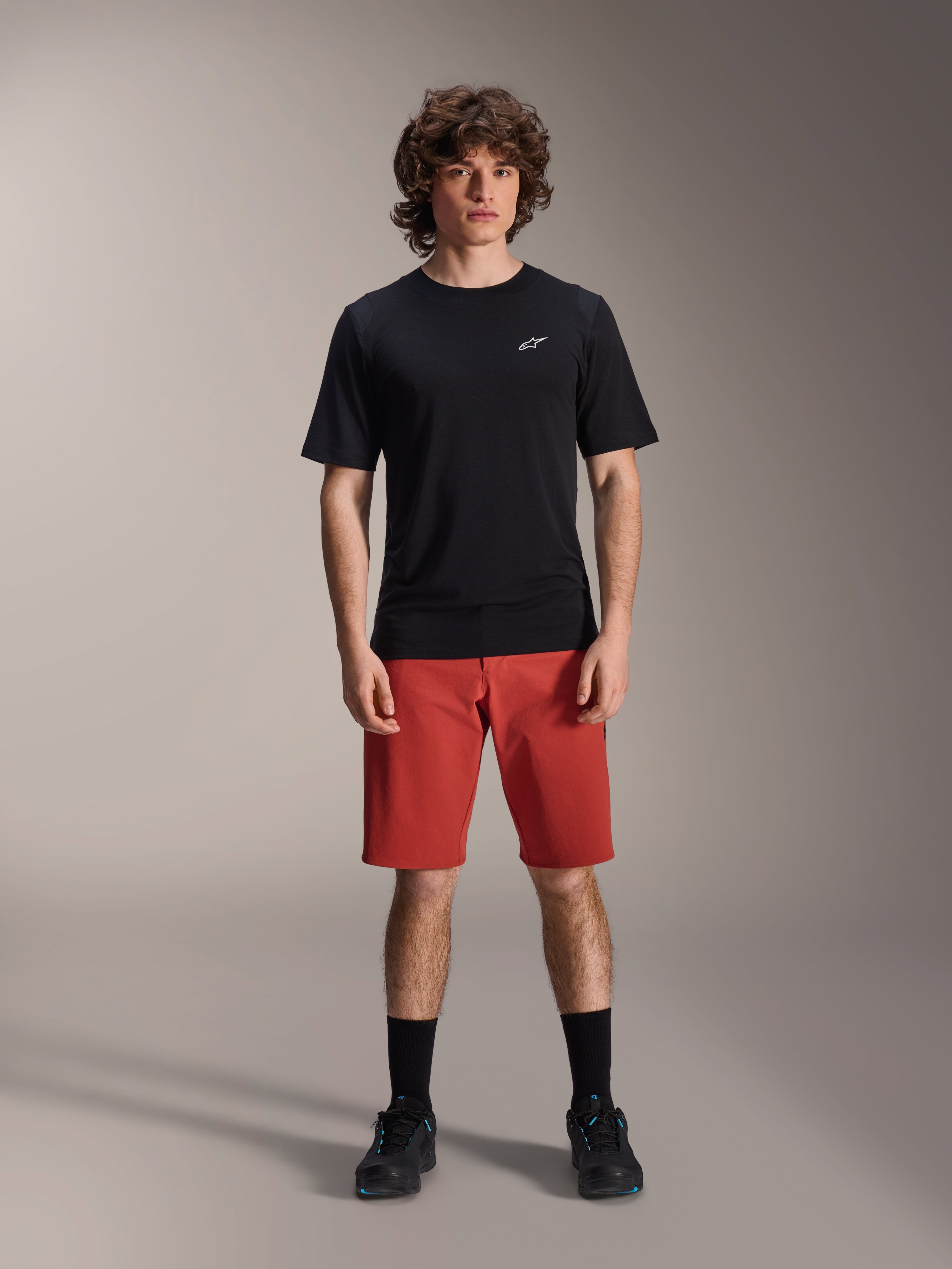 Alpinestars A-Dura Elite Shorts, MTB-shorts för mountainbike, mörkorange, bärs med en svart kortärmad tröja och cykelskor, teknisk cykelutrustning för mountainbike