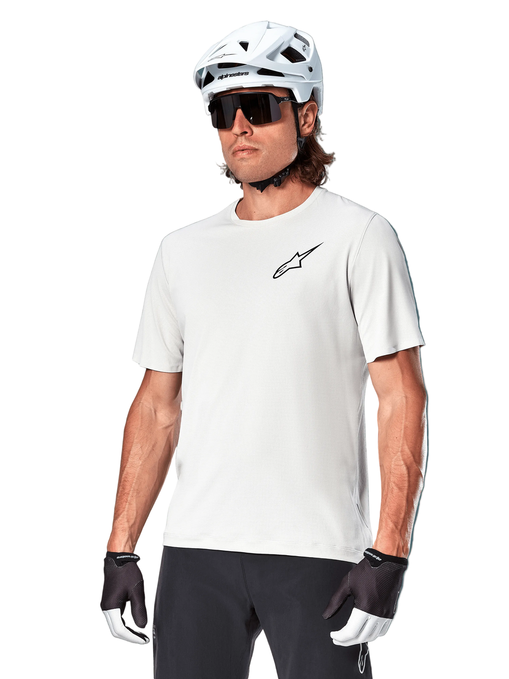 Alpinestars A-Aria Astar kortärmad tröja, White Dove, bärs av en cyklist med vit hjälm och mörka solglasögon, med en liten svart stjärnlogotyp på bröstet, ventilerande funktionsplagg för mountainbike