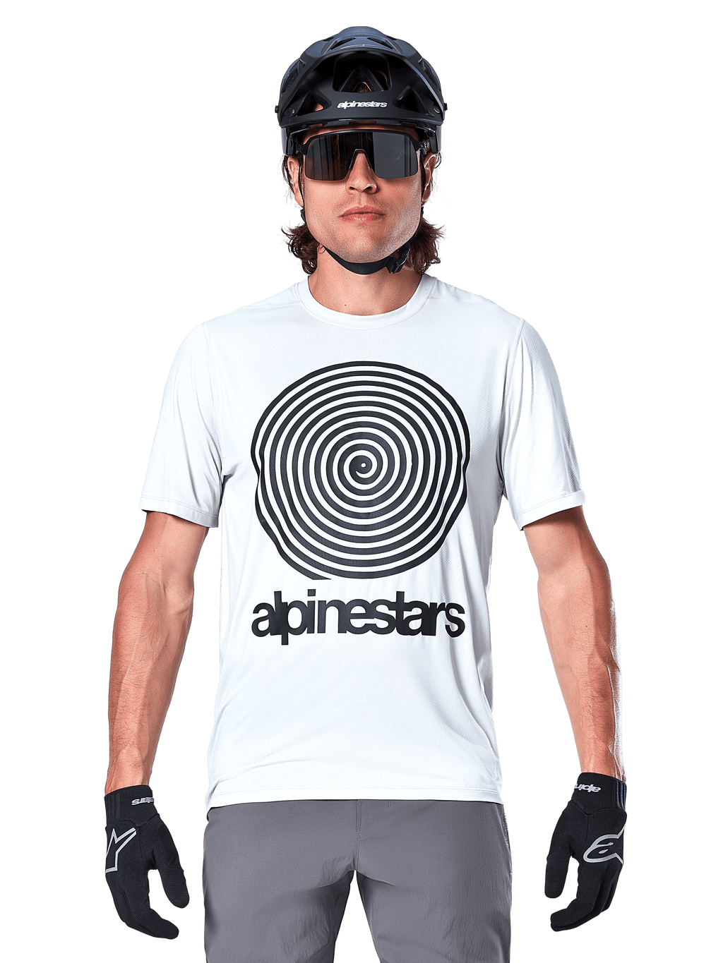 Alpinestars A-Dura Oscar-tröja - kortärmad, White Dove, med en stor svart vintage Oscar-spiralgrafik och Alpinestars-ordmärke på bröstet, bärs av en modell med svart MTB-hjälm, solglasögon och svarta handskar, heritage-cykelstil