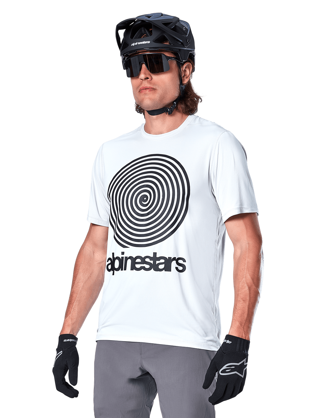 Alpinestars A-Dura Oscar-tröja - kortärmad, vit (White Dove) med svart heritage-spiralgrafik och logotyp, bärs med svart MTB-hjälm och handskar, sportiga och funktionella mountainbike-kläder
