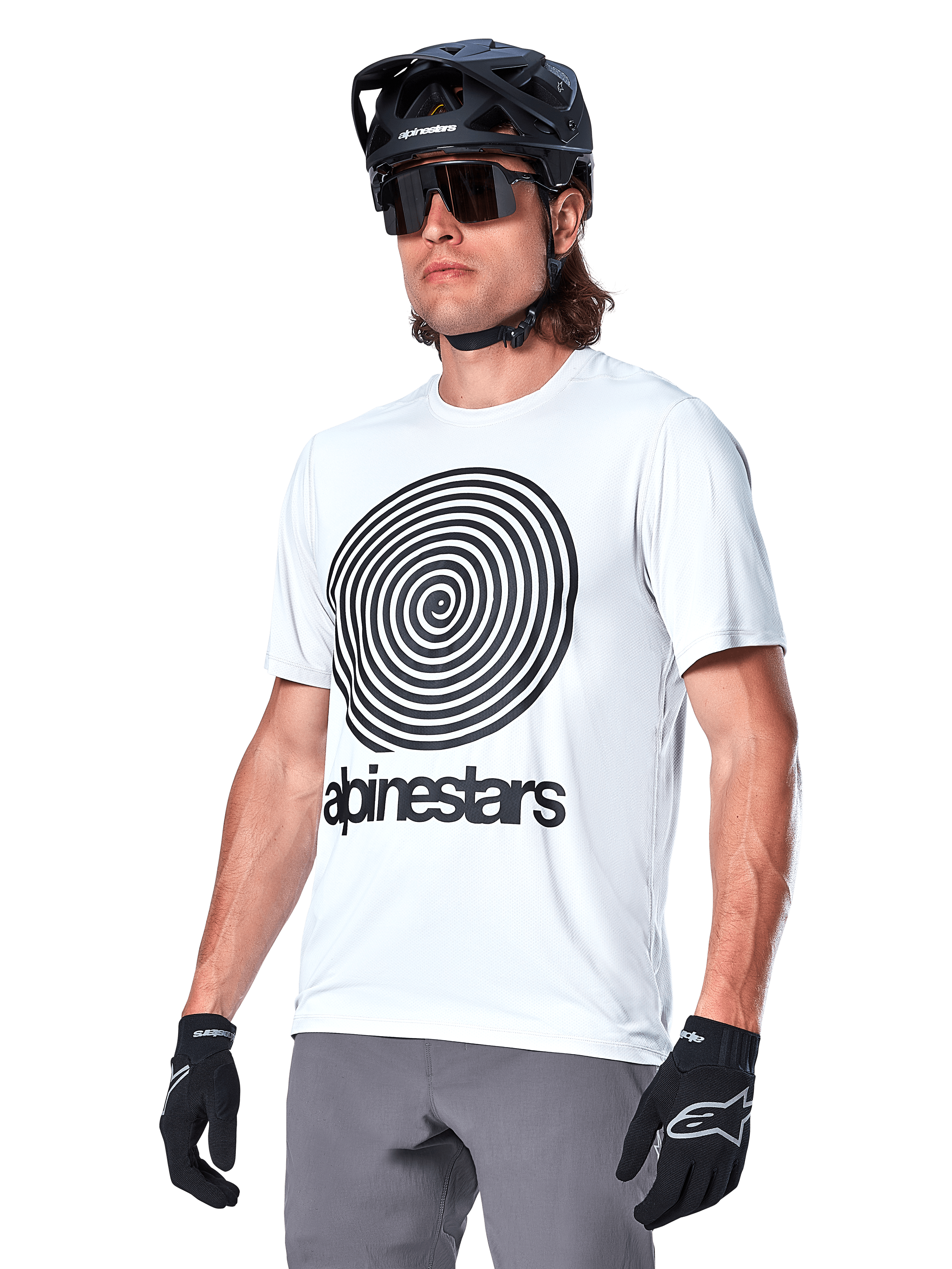 Alpinestars A-Dura Oscar-tröja - kortärmad, vit (White Dove) med svart heritage-spiralgrafik och logotyp, bärs med svart MTB-hjälm och handskar, sportiga och funktionella mountainbike-kläder