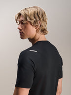Man som bär Alpinestars A-Aria Switch-tröja, kortärmad, svart, vy från sidan och bakifrån som visar prestandapassform och axeldetaljer, lätta och andningsbara MTB-cykelkläder