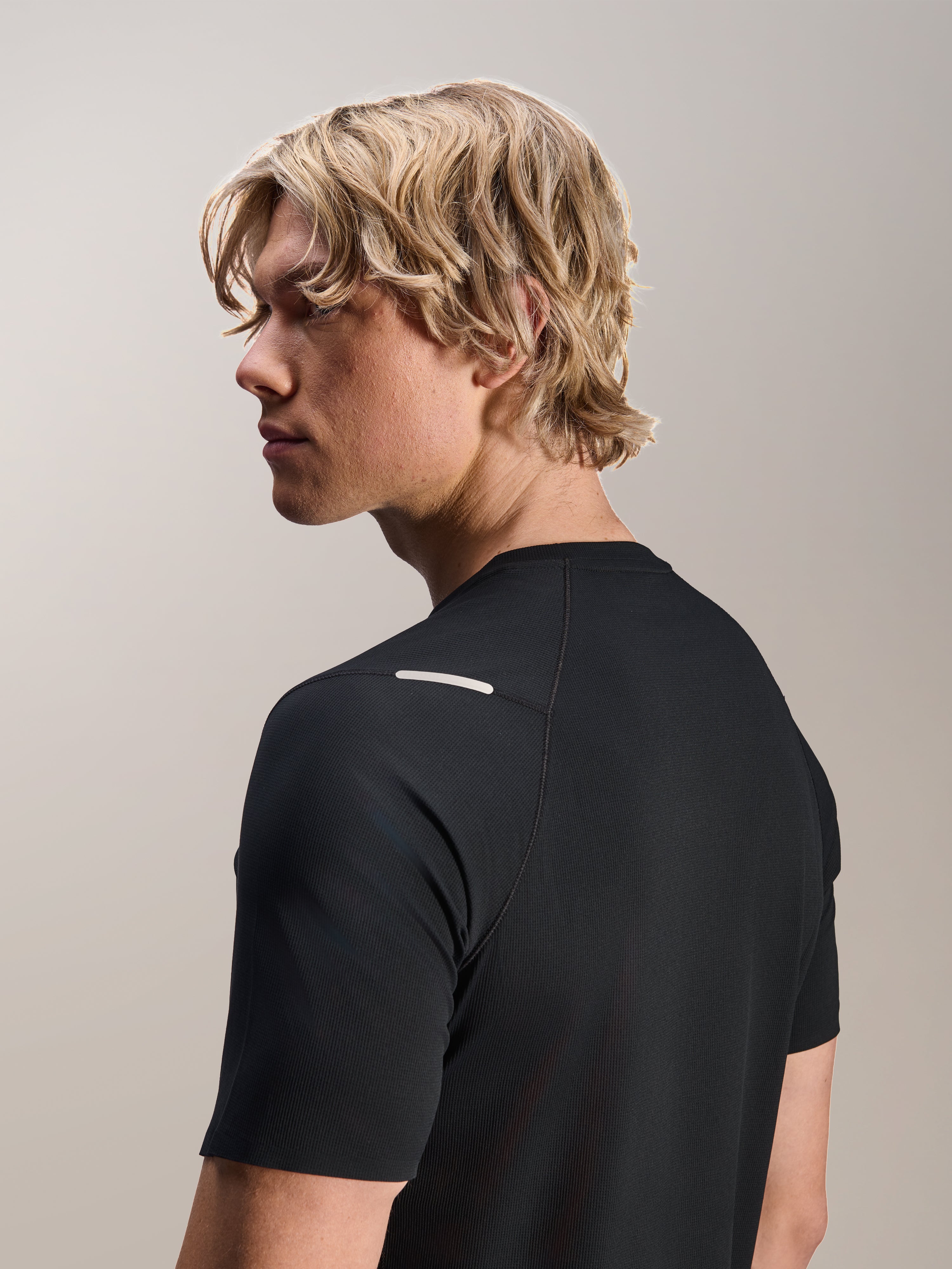 Man som bär Alpinestars A-Aria Switch-tröja, kortärmad, svart, vy från sidan och bakifrån som visar prestandapassform och axeldetaljer, lätta och andningsbara MTB-cykelkläder