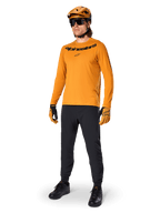 Alpinestars A-Dura Rocker Long Sleeve Jersey, Dark Gold cycling jersey, worn with matching MTB helmet and black pants, featuring black wordmark chest logo, coordinated performance gear for off-road mountain biking