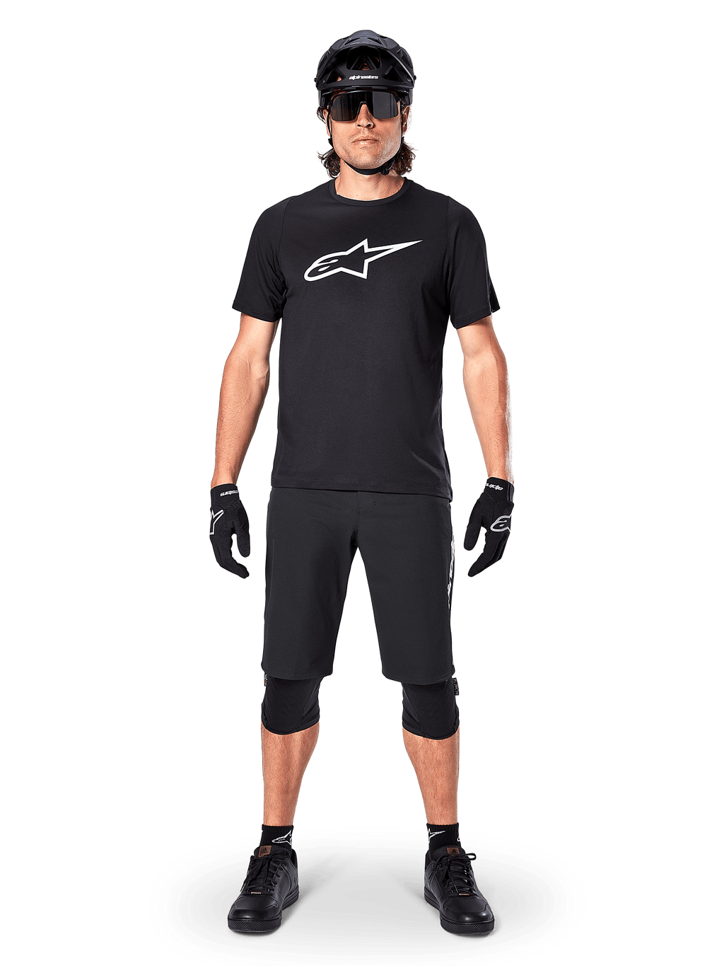 Alpinestars A-Dura Dri Oscar kortärmad tröja, Black Reflective, bärs med matchande svarta MTB-shorts, handskar, knäskydd och hjälm, med en stor vit Alpinestars-logotyp på bröstet, komplett mountainbike-outfit