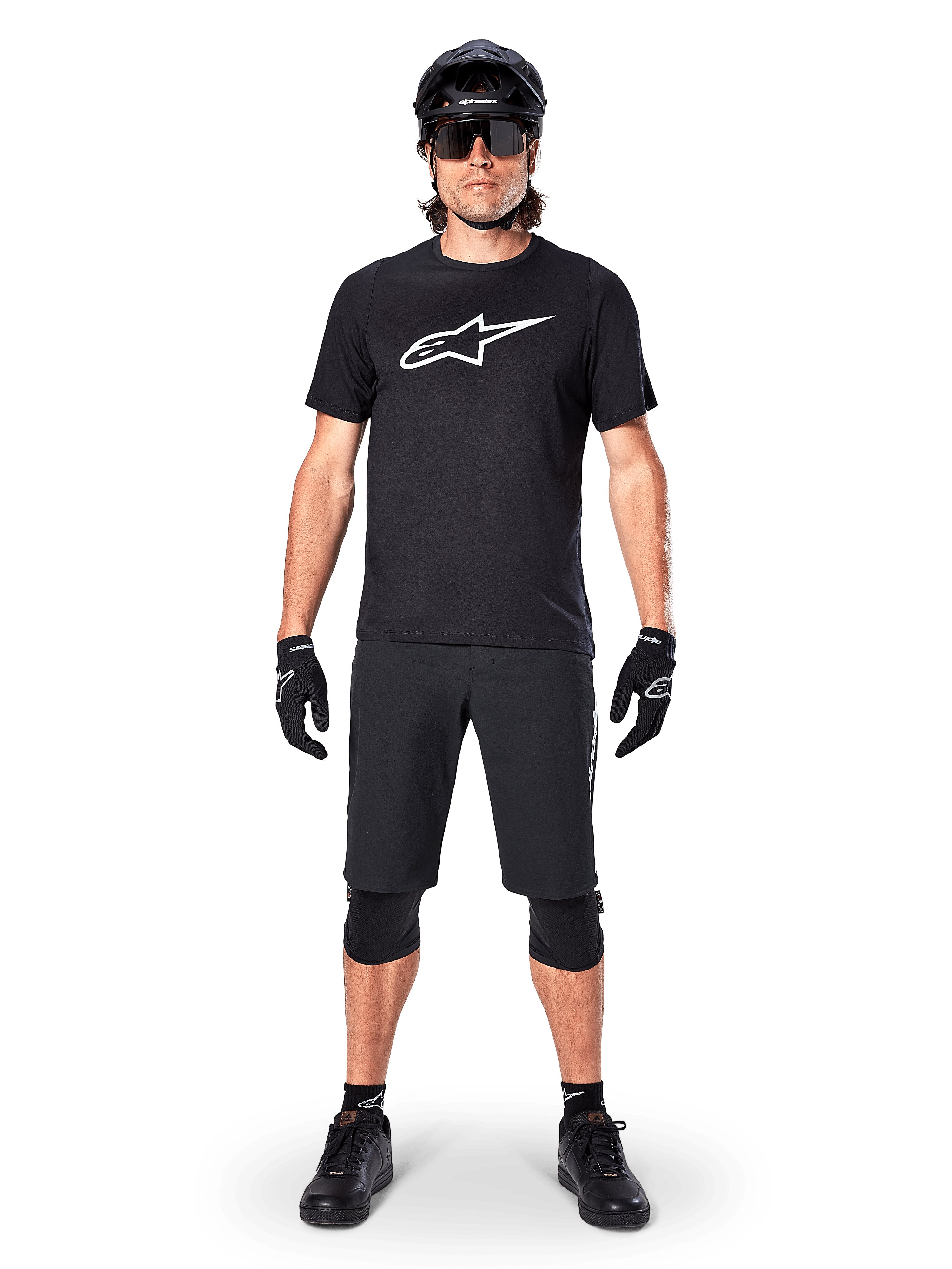 Alpinestars A-Dura Dri Oscar kortärmad tröja, Black Reflective, bärs med matchande svarta MTB-shorts, handskar, knäskydd och hjälm, med en stor vit Alpinestars-logotyp på bröstet, komplett mountainbike-outfit