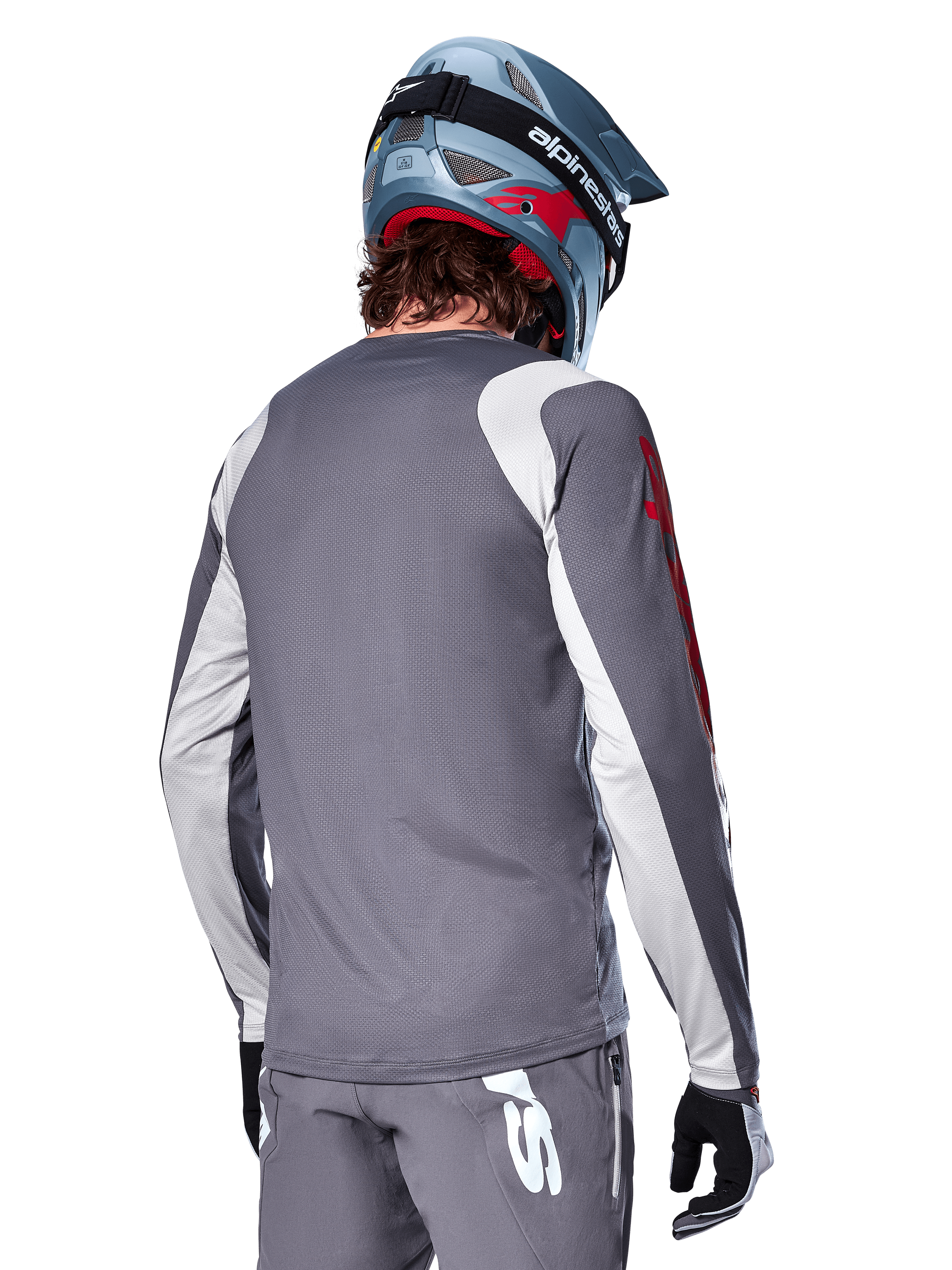 Alpinestars A-Supra Astar långärmad tröja, mörkgrå med ljusgrå axel- och ärmpaneler, vy bakifrån av cyklist med blå fullface-mountainbikehjälm och gråa byxor, MTB-cykelkläder med prestandapassform