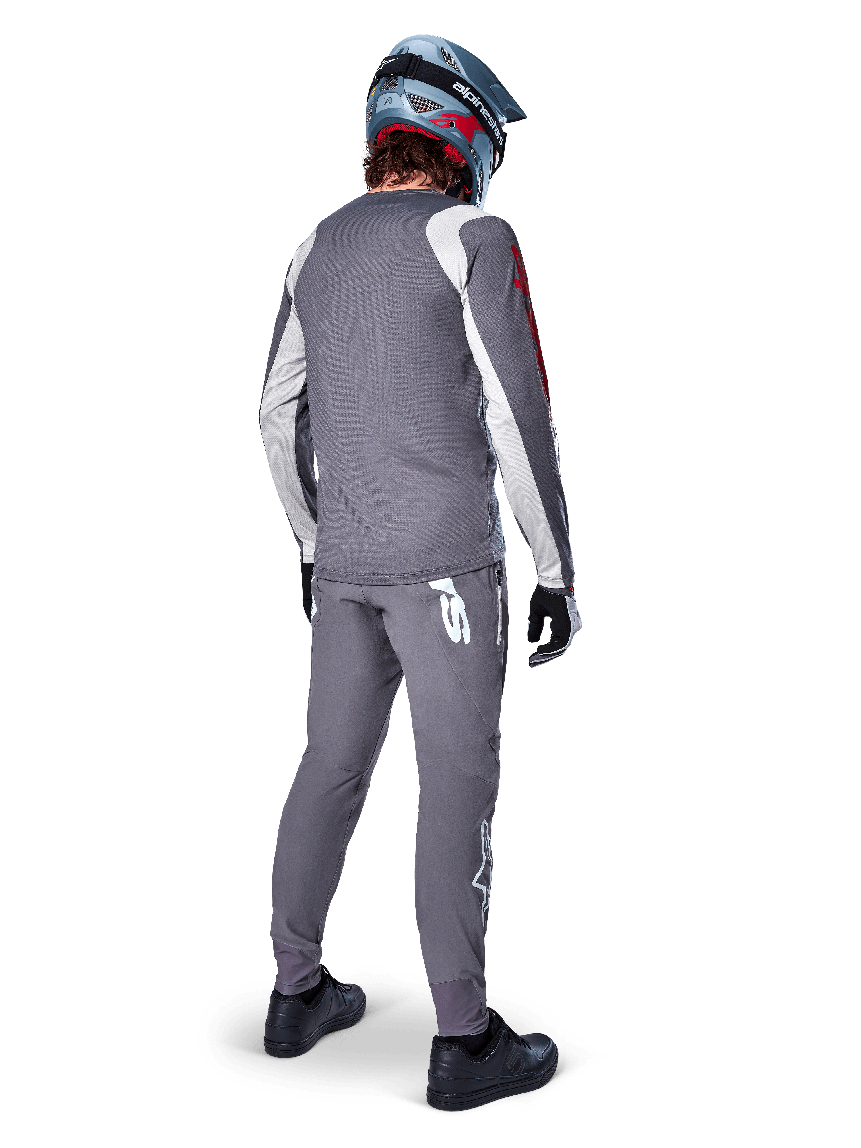 Alpinestars A-Supra Astar-tröja, långärmad MTB-tröja, mörkgrå med vita detaljer på ärmarna och röd logotyp, ryggvy av cyklist som bär matchande gråa byxor och blå fullface-hjälm, prestandakläder för cykling