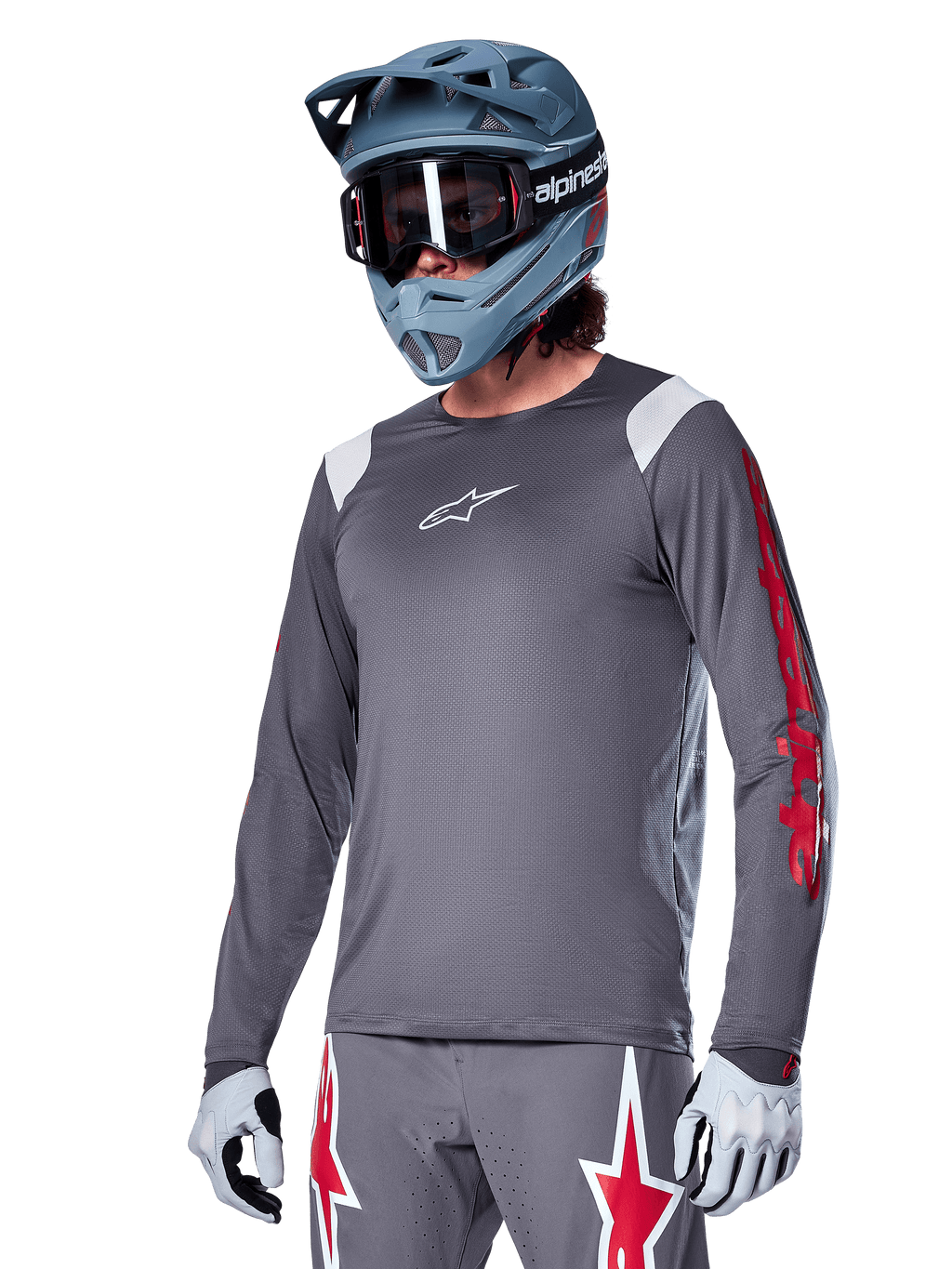 Alpinestars A-Supra Astar långärmad tröja, MTB-tröja, mörkgrå med röda och vita detaljer, prestandapassform, bärs med matchande grå byxor med röd och vit stjärngrafik, komplett outfit för terrängcykling med fullface-hjälm och handskar