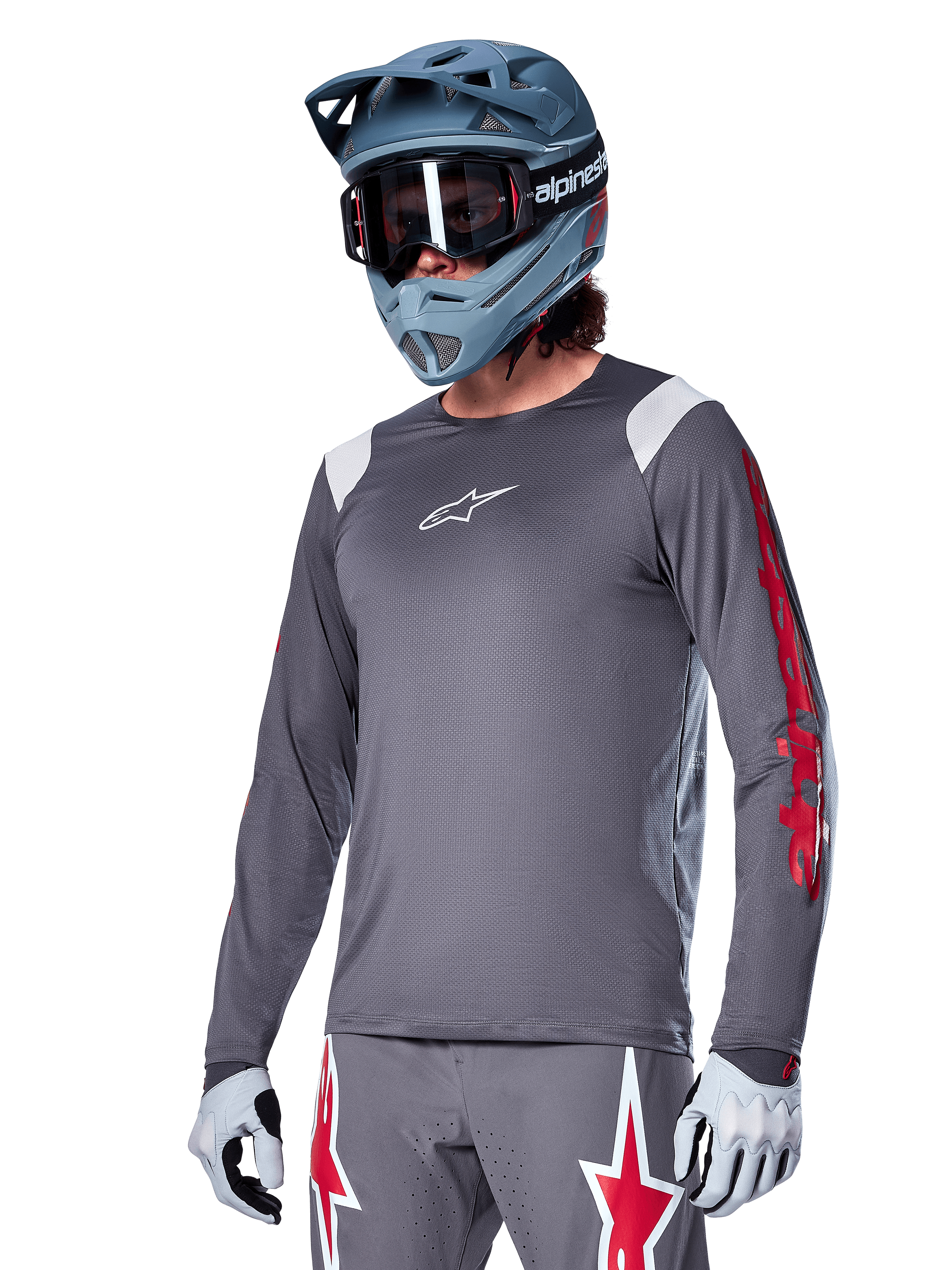 Alpinestars A-Supra Astar långärmad tröja, MTB-tröja, mörkgrå med röda och vita detaljer, prestandapassform, bärs med matchande grå byxor med röd och vit stjärngrafik, komplett outfit för terrängcykling med fullface-hjälm och handskar
