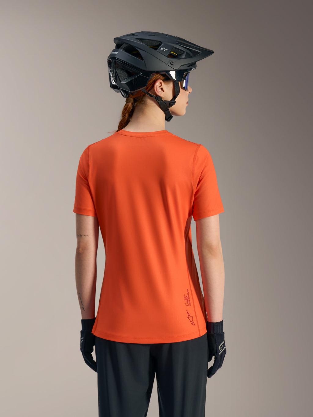 Orange Stella A-Dura Ride-tröja för damer, ryggvy av kortärmad MTB-topp i återvunnet funktionsmaterial.