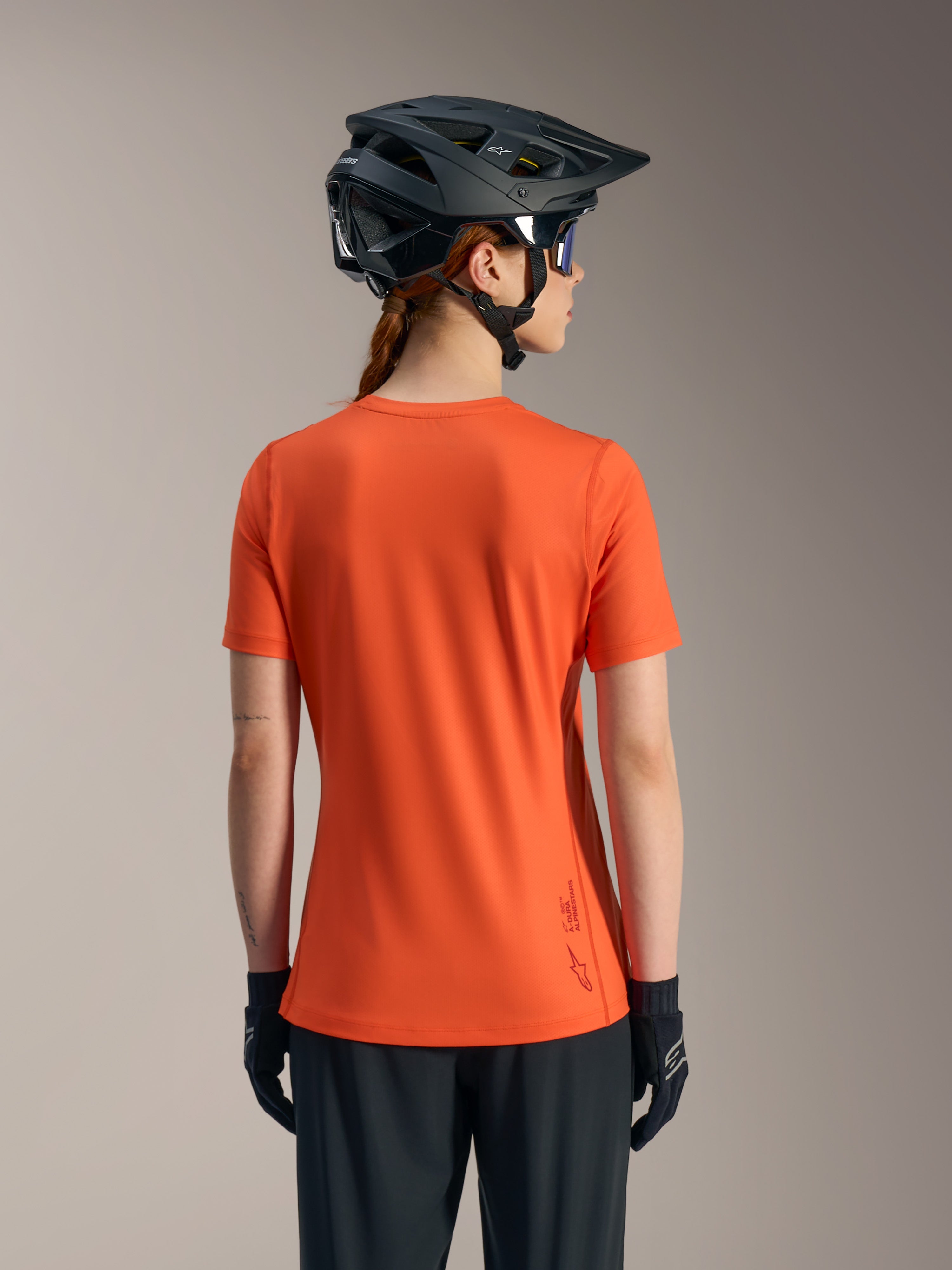 Orange Stella A-Dura Ride-tröja för damer, ryggvy av kortärmad MTB-topp i återvunnet funktionsmaterial.