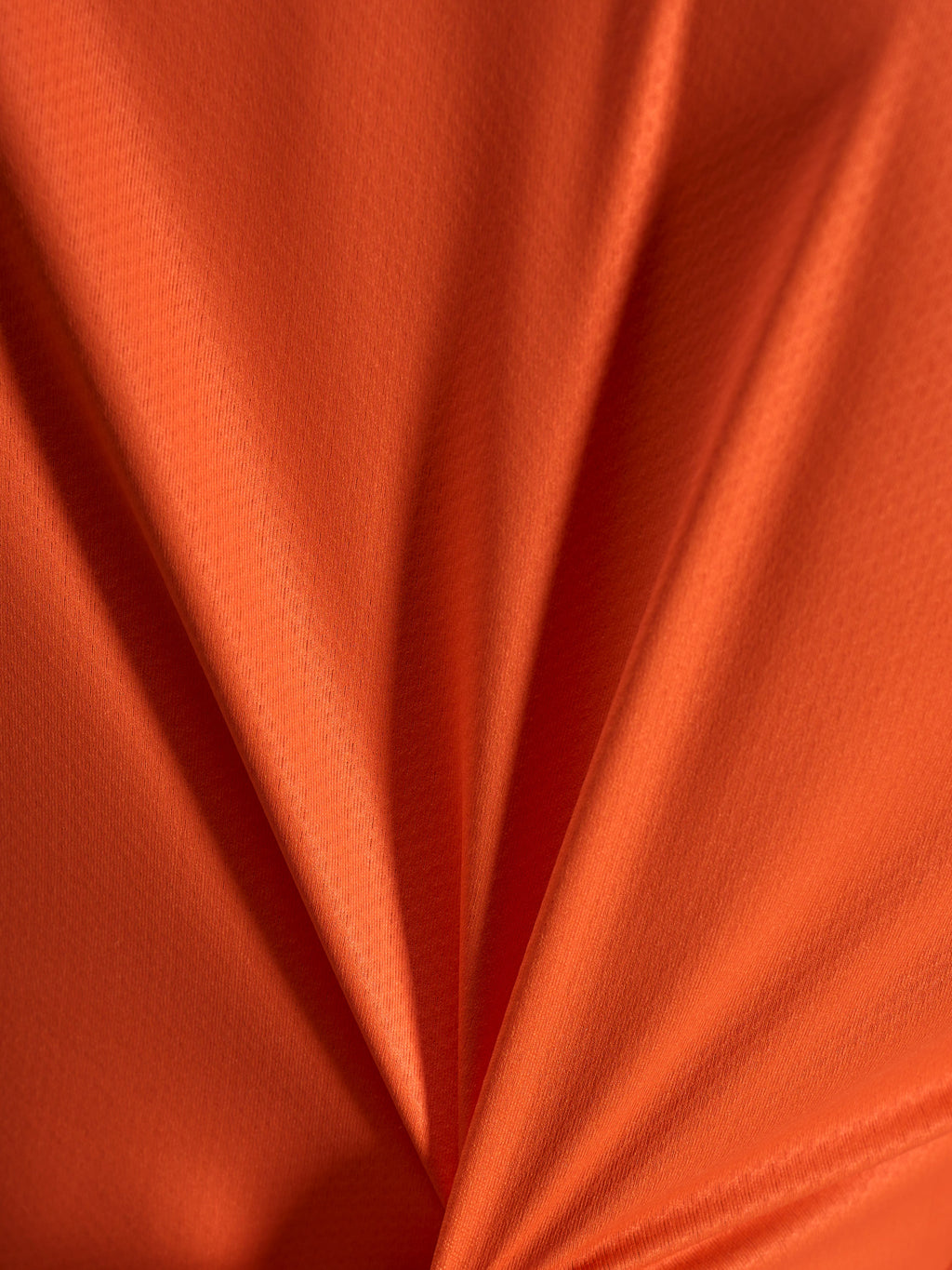 Närbild på orange jacquardtyg på Alpinestars Stella A-Dura Ride-tröja med lätt och stretchig textur.