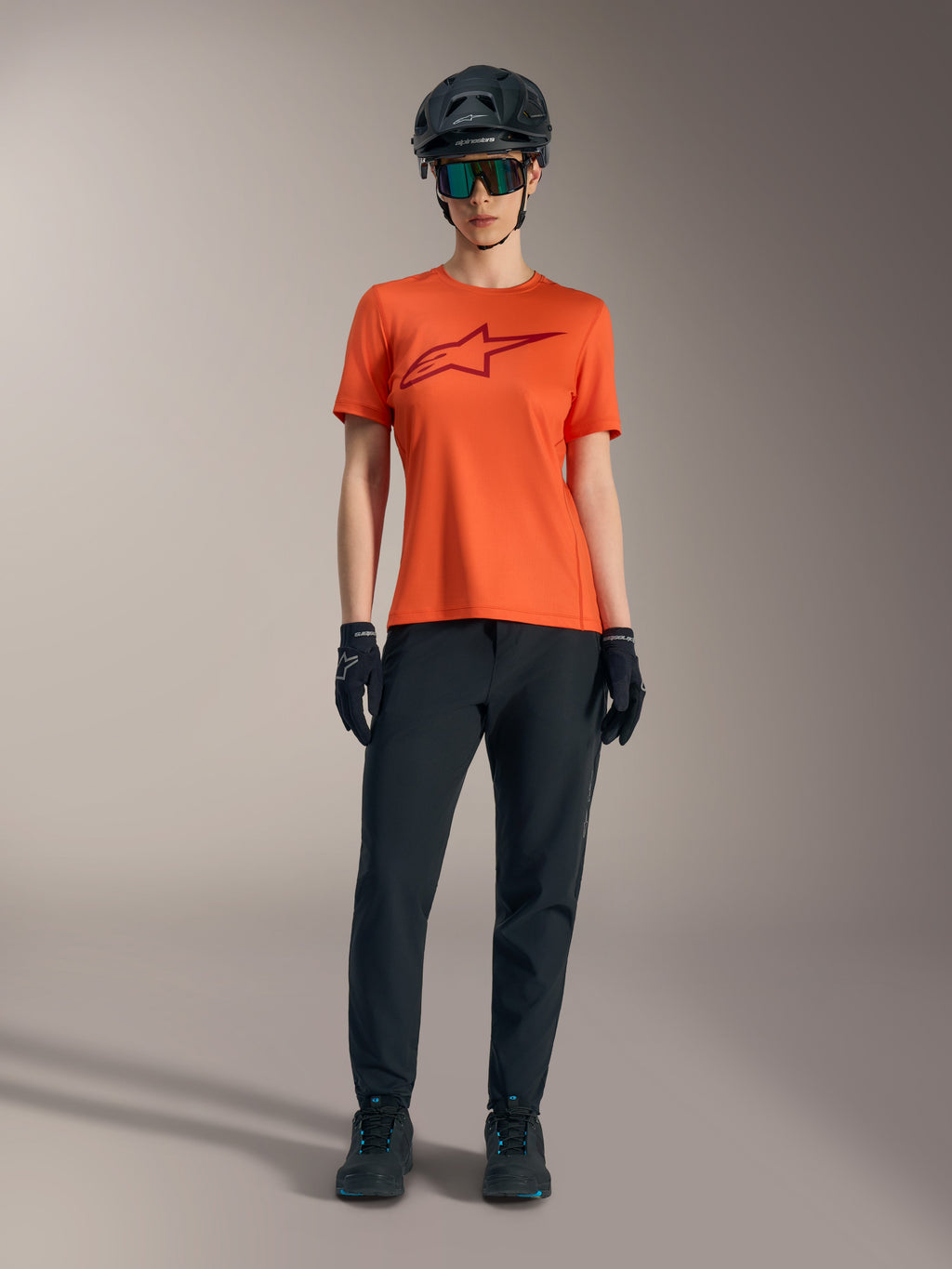 Alpinestars orange Stella A-Dura Ride kortärmad tröja med vinröd logotyp, svarta MTB-byxor, hjälm och handskar.
