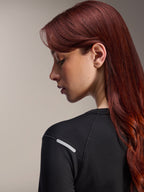 Alpinestars Stella A-Dura Thermal-tröja, långärmad MTB-tröja för dam, svart, närbild från sidan som framhäver den reflekterande silverremsan på axeln, tekniskt isolerande material för mountainbike