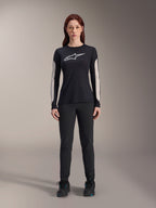 Kvinna i Alpinestars Stella A-Dura Dri Astar långärmad tröja, svart med vit logotyp på bröstet och ljusa meshpaneler på ärmarna, kombinerat med svarta byxor och svarta skor, tekniska mountainbikekläder