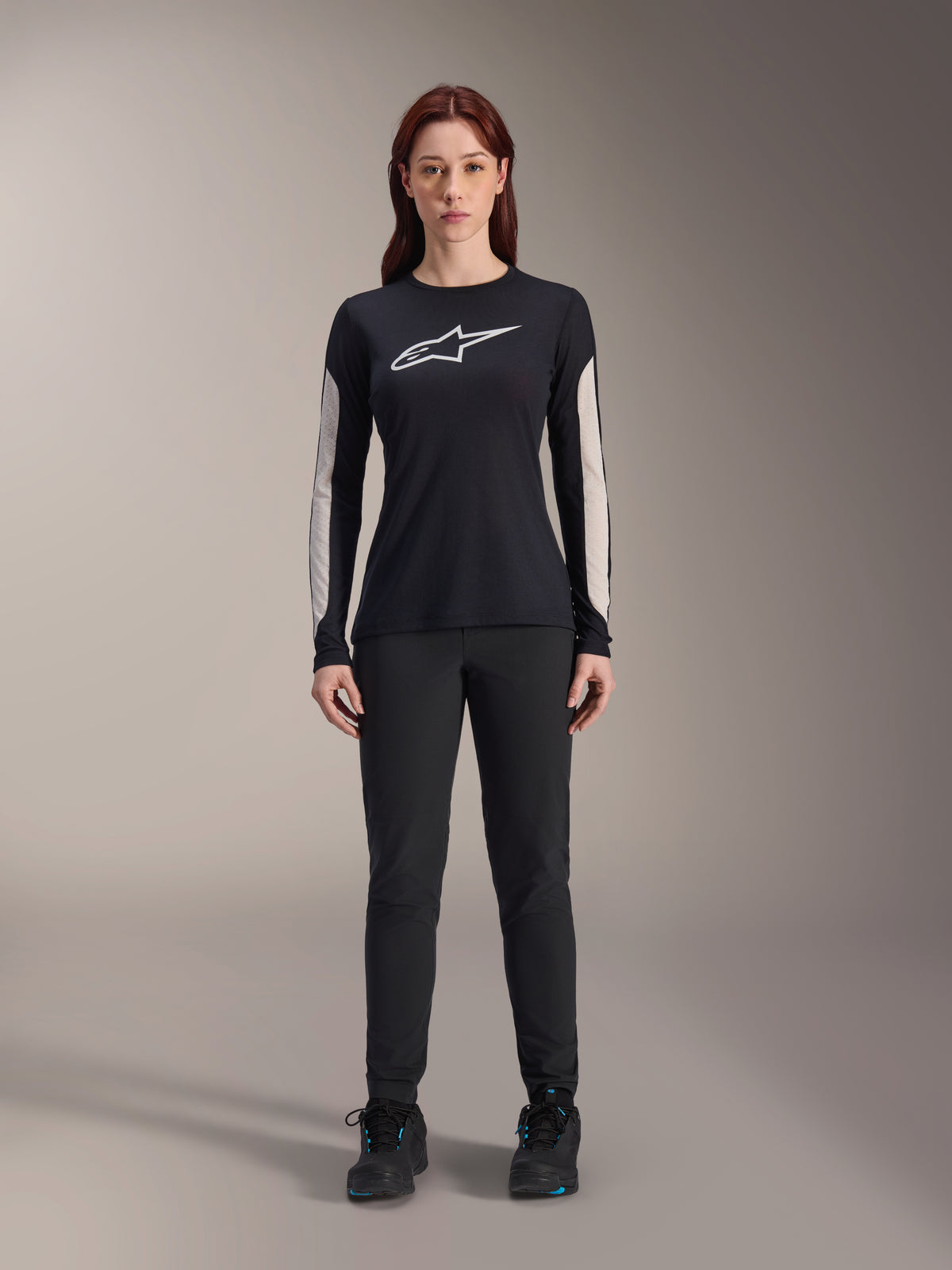 Alpinestars Women Stella A-Dura Pants, Black MTB Pants, featuring a dedicated women's fit with a streamlined design, paired with a black long-sleeve jersey and black cycling shoes, durable gear for off-road mountain biking
