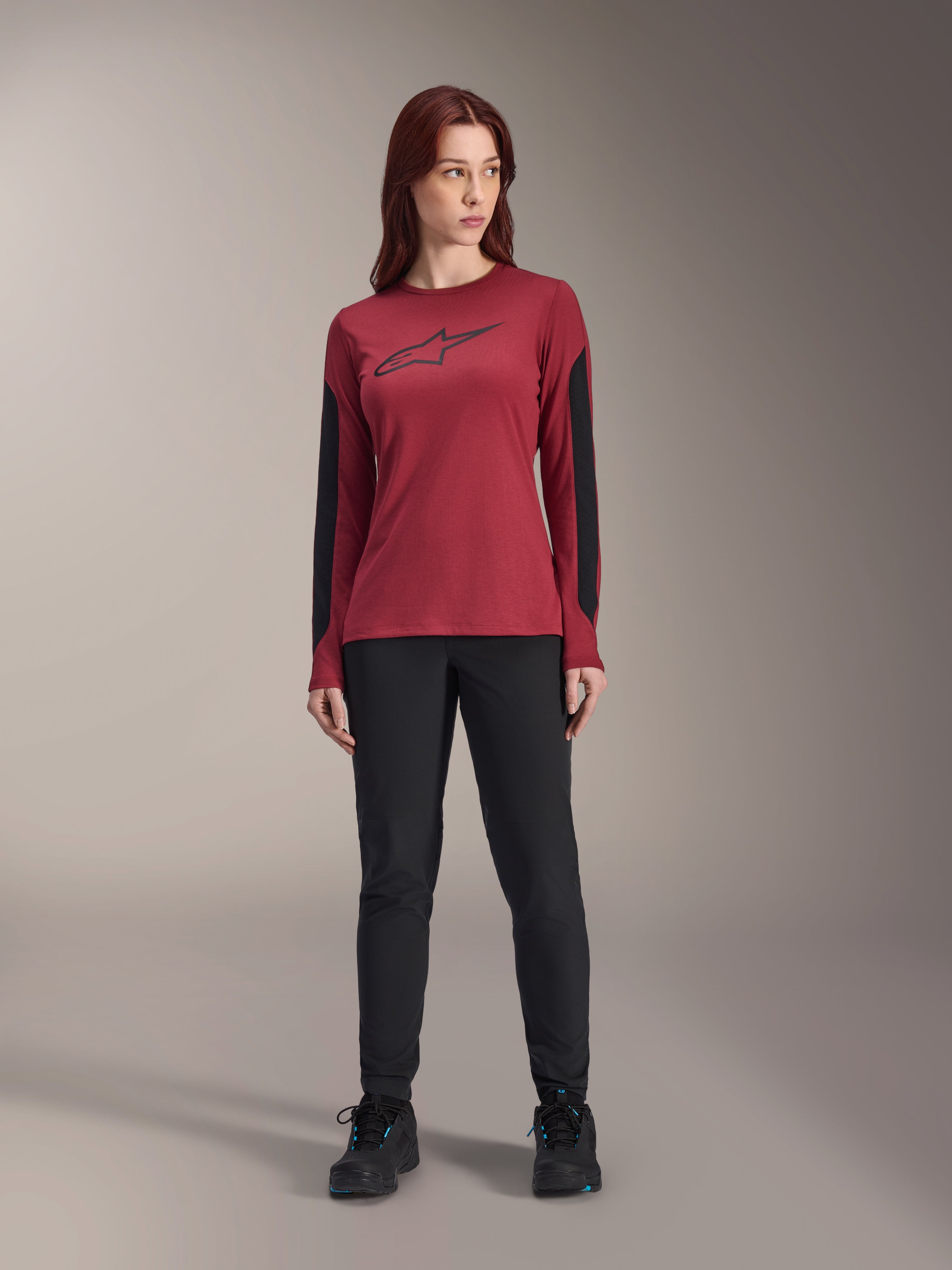 Alpinestars Stella A-Dura Dri Astar långärmad tröja för damer, burgundy med svart Astars-logotyp på bröstet och svarta meshpaneler på ärmarna, stylad med svarta tekniska byxor och sportskor, högpresterande mountainbike-kläder för damer