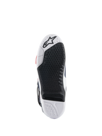 Alpinestars Tech 10 Supervented-stövlar, sula sedd underifrån, svart och vit design i dubbel gummiblandning, bikakeformat greppmönster, utbytbar central sulinsats, präglad Alpinestars-logotyp, optimerad för prestanda på motocross-fotpinnar.