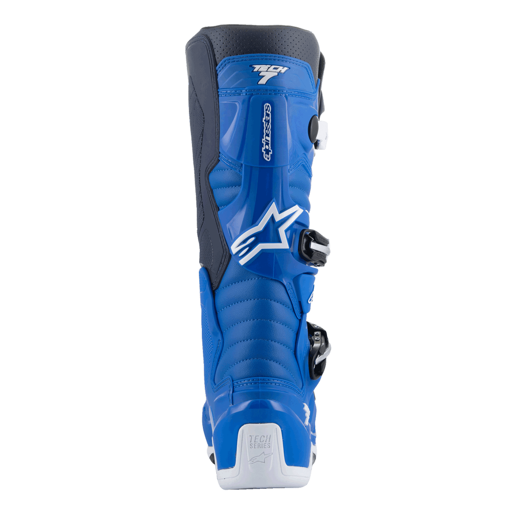 Alpinestars Tech 7-stövlar, motocrossstövlar, Alpine Blue och Night Navy med vita detaljer, baksida som visar det konturerade vadskyddet, vit hälförstärkning med Tech Series-logotyp och detaljer av spännsystemet på sidan.