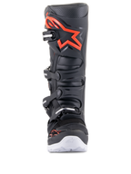 Alpinestars Tech 7 Enduro-stövlar, svarta och fluoröda, sedda framifrån, med en stor röd logotyp på skenbensplattan, stängningssystem med fyra spännen och vita detaljer på yttersulan, professionella stövlar för motocross och terrängkörning