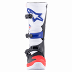 Alpinestars Tech 3-stövlar, motocrossstövlar, vita, klaröda och mörkblå, vy framifrån som visar den skyddande TPU-skenbensplattan med blå logotyp, stängningssystem med tre spännen och förstärkt rött tåparti