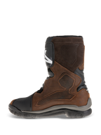 Alpinestars Belize Drystar® Boots, short-calf adventure touring motorcycle boots, oiled brown leather with black and grey accents, showing the medial side with a large heat-press textured grip panel, TPU shin plate, and rugged vulcanized rubber sole
