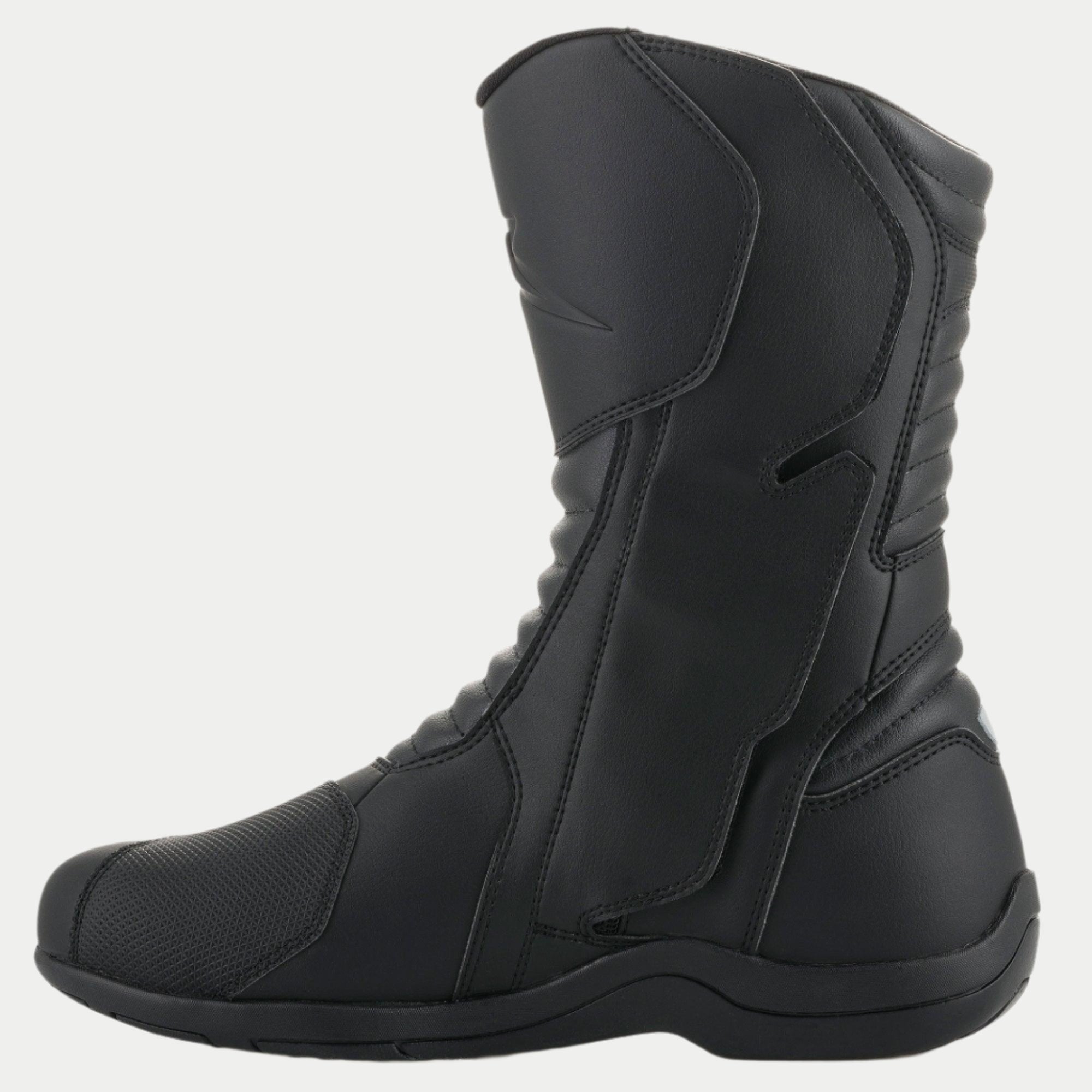 Alpinestars Origin Drystar® Boots, Black Motorcycle Touring Boots, side profile view of the medial side showing the entry system flap, microfiber upper with front and rear accordion flex zones, durable waterproof design for road and adventure riding