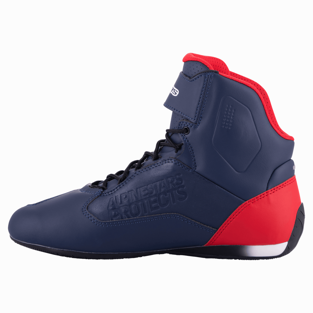 Alpinestars Austin Riding Shoe, Night Navy och Bright Red, profilvy som visar den marinblå ovandelen i mikrofiber med röda detaljer på häl och krage, svarta skosnören, präglad "Alpinestars Protects"-logotyp, hög MC-sko