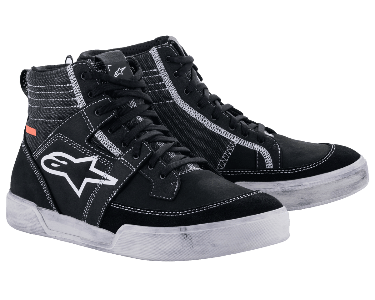 Alpinestars Ageless motorskor, urbana motorcykelskor, svarta med vita kontrastsömmar och sulor, high-top sneaker-silhuett med en stor vit stjärnlogotyp på sidan, avslappnad skyddsutrustning för vägkörning