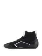 Alpinestars Supertech-skor, bilsportskor, svarta, sidoprofilvy med stickad ovandel, hälkopp i kolfiber och vita geometriska detaljer, professionella skor för motorsport