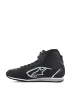 Alpinestars Radar-skor, depåskor för racing, svarta och vita, hög profil med ovandel i perforerat läder, ikonisk vit A-stjärna-logotyp på sidan och justerbart kardborreband vid vristen.