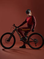 Alpinestars A-Dura Elite-set i bordeaux, tröja och byxor på en cyklist med Specialized-cykel i studiomiljö.
