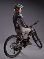 Grå långärmad A-Dura Race-tröja på en mountainbikecyklist, med stora Alpinestars-logotyper och funktionellt stretchtyg.