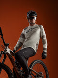 A-Dura Ride långärmad tröja i Sand Camo med Alpinestars logotyp, buren av en MTB-cyklist på en mountainbike.