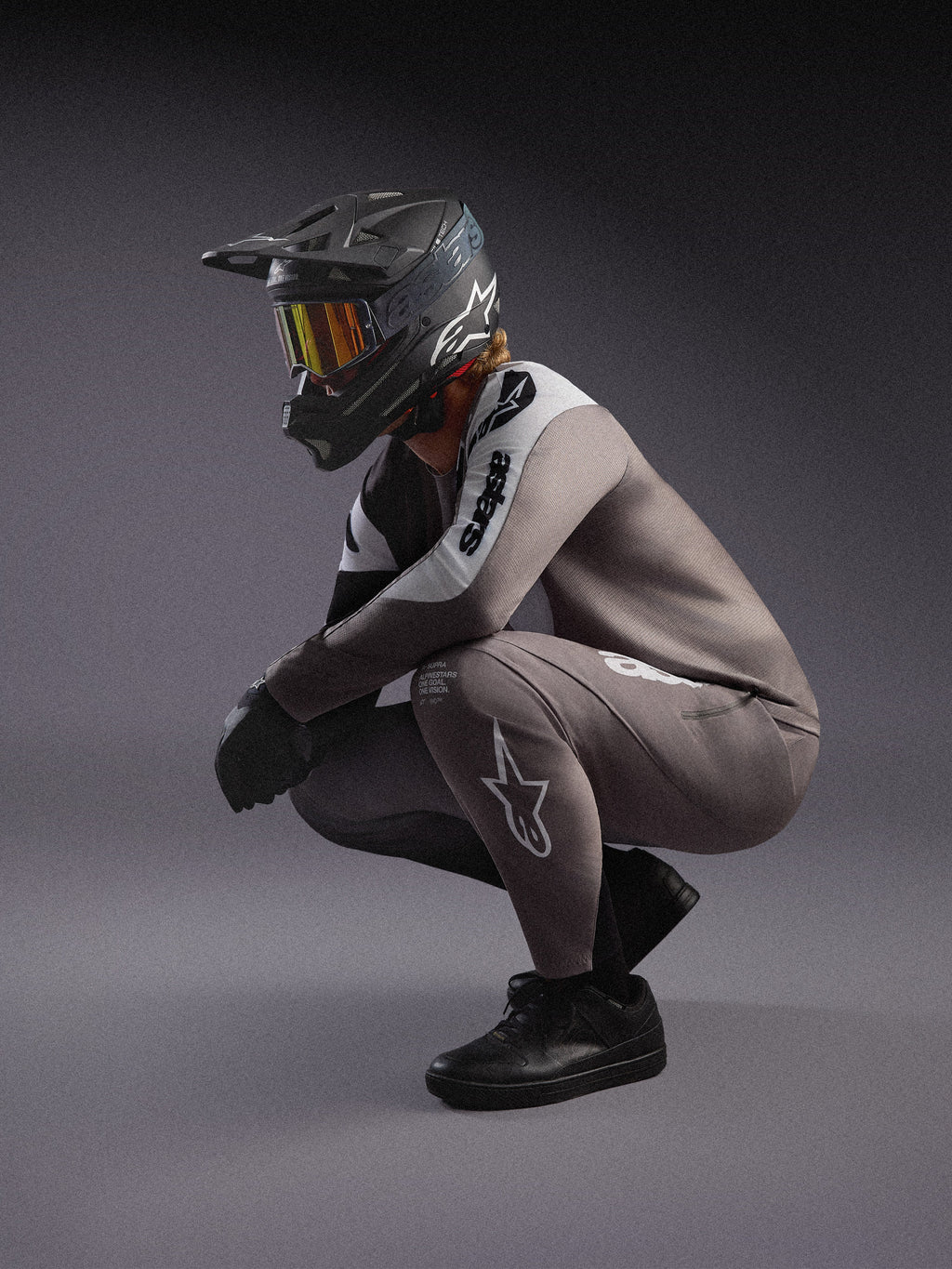 Gråtonad A-Supra Elite MTB-tröja och matchande byxor, stylad med svart fullface-hjälm och goggles för racing.