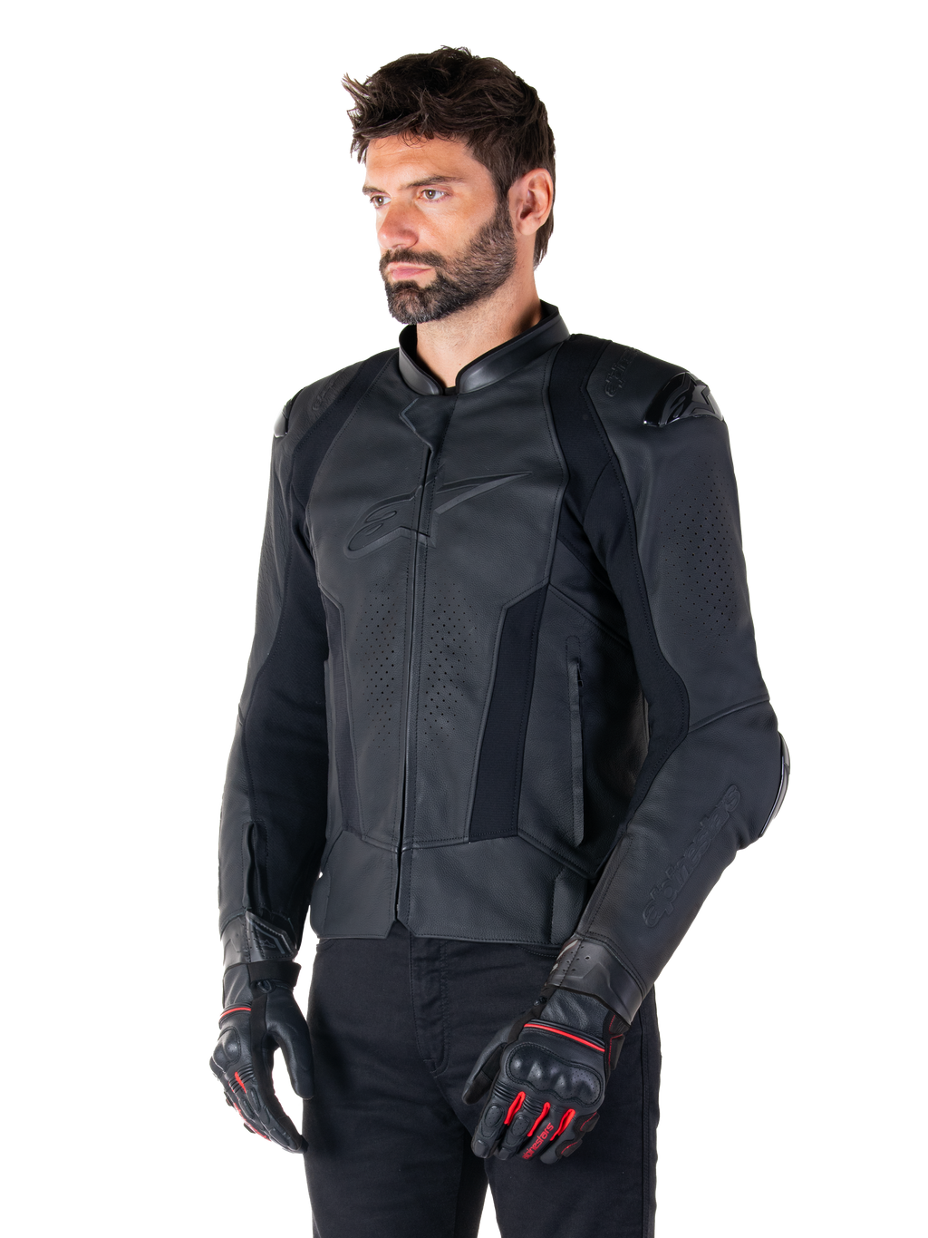 Manlig förare iklädd Alpinestars Missile V3 läderjacka i svart, premium nötläder med perforerade bröstpaneler och externa DFS-axelskydd, kombinerad med svarta byxor och svart-röda racinghandskar.
