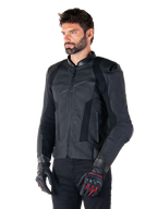 Manlig förare iklädd Alpinestars Missile V3 läderjacka i svart, premium nötläder med perforerade bröstpaneler och externa DFS-axelskydd, kombinerad med svarta byxor och svart-röda racinghandskar.