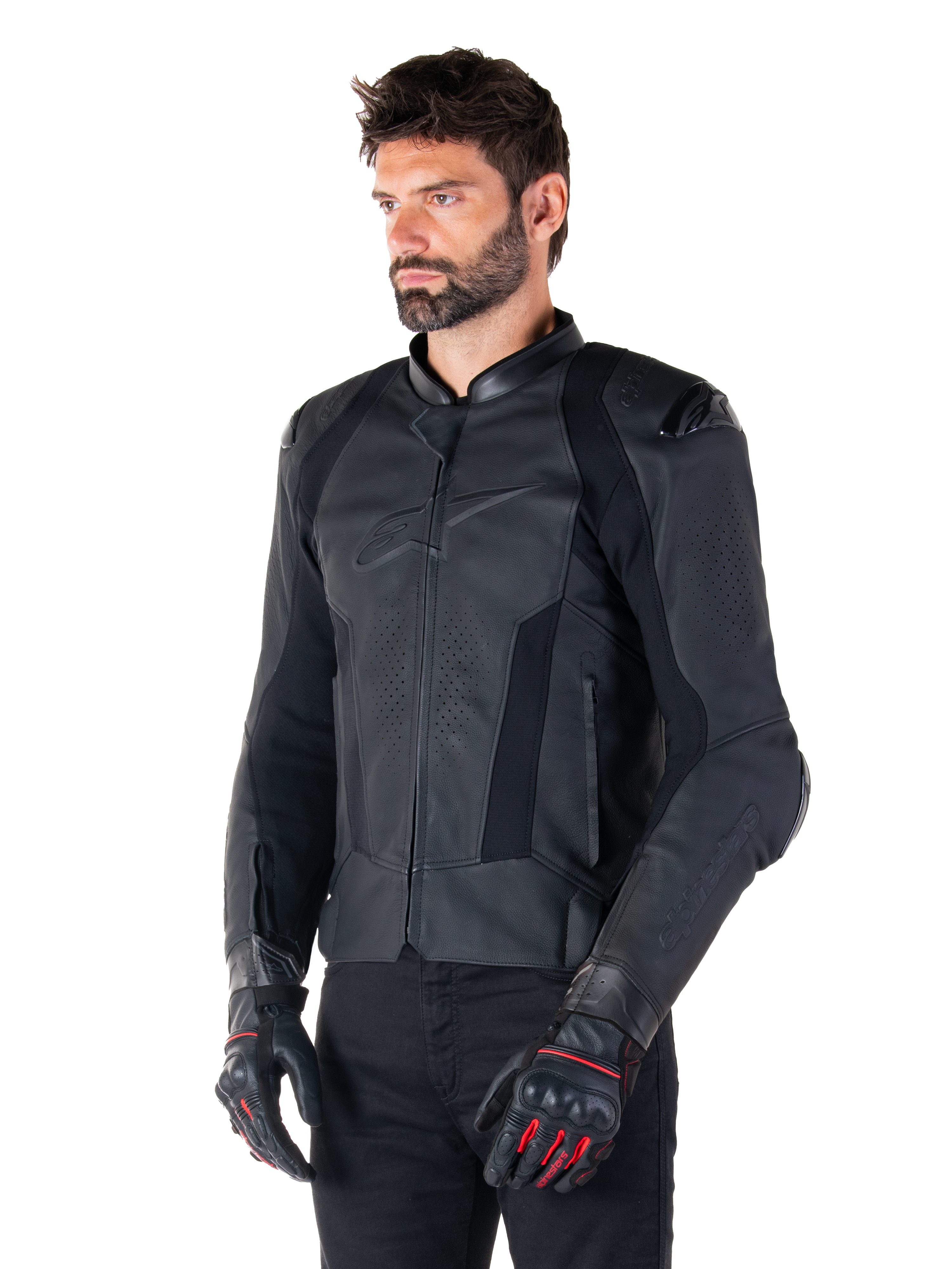 Manlig förare iklädd Alpinestars Missile V3 läderjacka i svart, premium nötläder med perforerade bröstpaneler och externa DFS-axelskydd, kombinerad med svarta byxor och svart-röda racinghandskar.