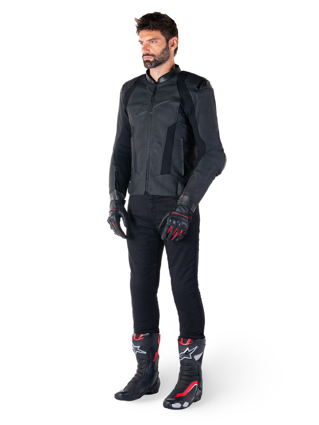 Alpinestars Missile V3 läderjacka, svart, bärs av en förare med svarta byxor och svart-röda racinghandskar och stövlar, med perforerade läderpaneler och elegant monokrom logotyp, professionell racing-estetik