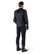 Alpinestars Missile V3 skinnjacka i svart, sedd bakifrån på en förare, bärs med svarta byxor och svart-röda racingstövlar, smidig skinnkonstruktion med logotyper ton-i-ton och en sportig race-passform