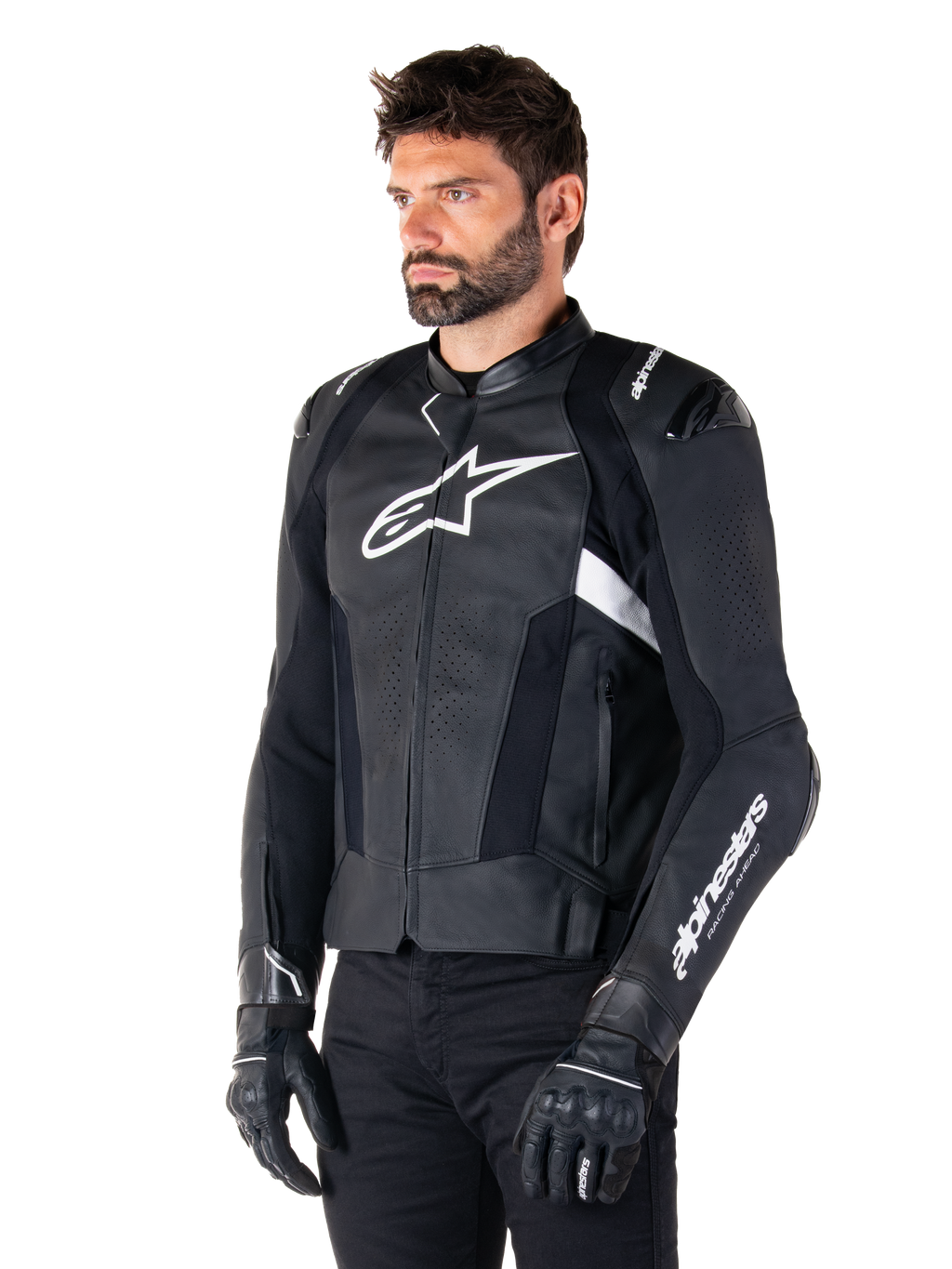 Alpinestars Missile V3 skinnjacka, svart och vit, bärs av en man med svarta körhandskar, med en framträdande vit Alpinestars-logotyp på bröstet, externa axelsliders och perforerade paneler för en racinginspirerad look.