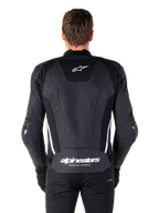 Ryggvy av Alpinestars Missile V3 skinnjacka i svart och vitt, med Alpinestars stjärnlogotyp på övre delen av ryggen och branding på ländryggen, vita vertikala ränder och externa armbågssliders, premium racing-sportjacka i skinn