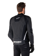 Alpinestars Missile V3 skinnjacka, baksida, svart och vit, med Alpinestars stjärnlogotyp på övre ryggen och ordmärke på nedre ryggen, skyddande sliders på armbågar och axlar, förstklassig racingutrustning i läder.