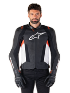 Alpinestars Missile V3 Läderjacka, Black White Red Fluo, premium racing-sportjacka i nötläder, med vit bröstlogotyp och Alpinestars-logotyper på ärmarna, bärs med svarta motorcykelhandskar och byxor