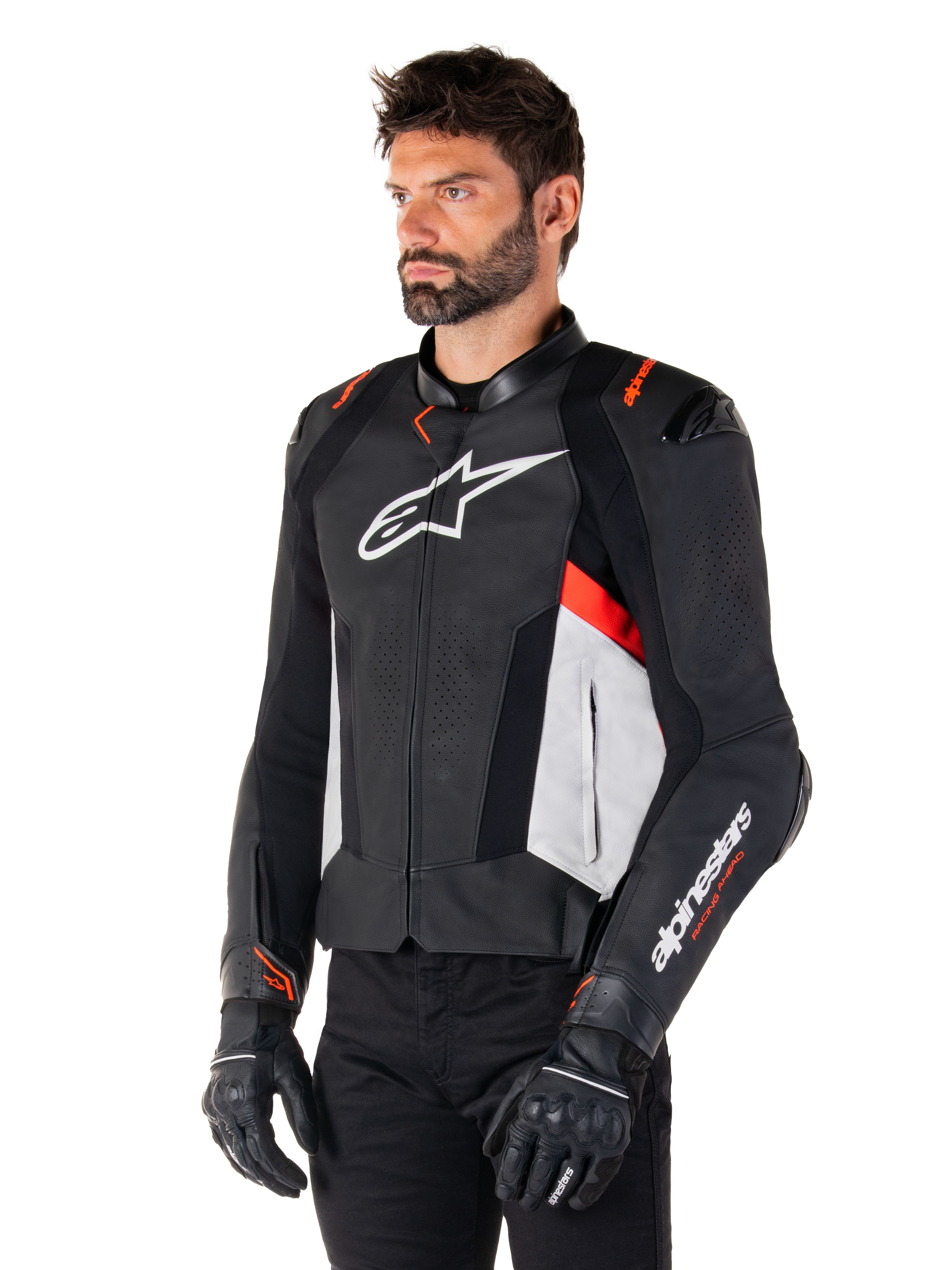 Alpinestars Missile V3 läderjacka, svart, vit och röd fluo, racing-sportjacka för motorcykel buren av en modell med svarta handskar och byxor, perforerade läderpaneler och tydlig Alpinestars-branding