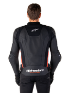 Alpinestars Missile V3 Läderjacka, baksida, premium svart läder med detaljer i röd fluo och vitt, med en vit stjärnlogotyp på övre delen av ryggen och Alpinestars-logotyp på nedre delen av ryggen, bärs med svarta byxor och handskar.