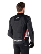 Alpinestars Missile V3 Läderjacka, ryggvy på en förare, svart, vit och röd fluo, med framträdande Alpinestars-logotyp och texten 'RACING AHEAD' på nedre delen av ryggen, premium läderkonstruktion med tekniska stretchpaneler och skyddande TPU-sliders, buren med svarta handskar och byxor.