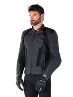 Alpinestars Missile V3 Airflow skinnjacka, svart, bärs av en man med svarta motorcykelhandskar och byxor, med omfattande perforerade läderpaneler, DFS-axelskydd och en stilren race-passform.